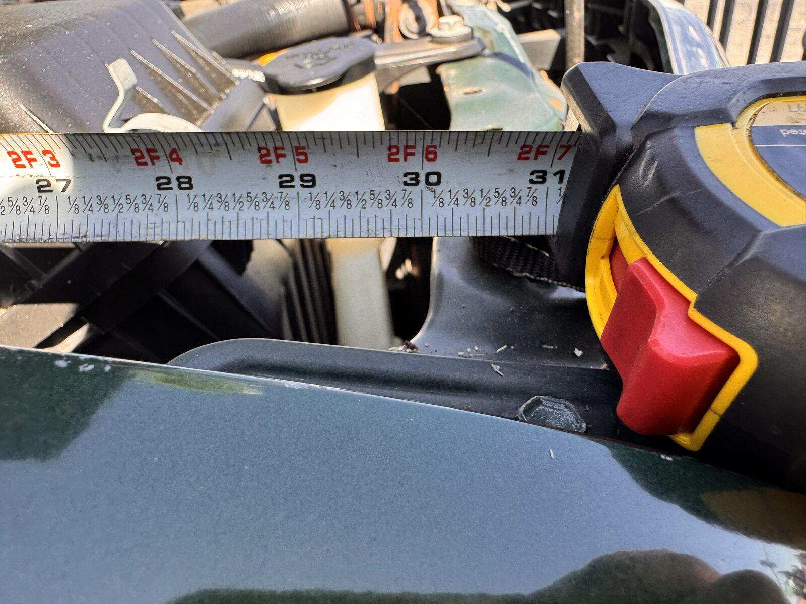 Tape measure laid across a fender during a panel and height measurement